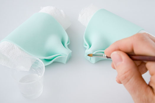 Змазування харчовим клеєм кінців петель банта з мастики