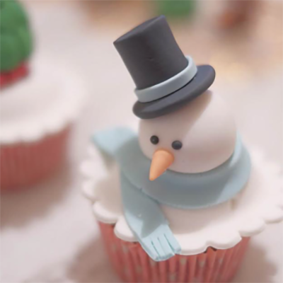 Снеговик в шляпе и с шарфом на кексе