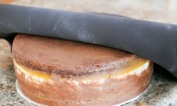 Черная мастика покрывает торт